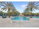 Resort-style pool with a waterslide, waterfall feature, and multiple lounge areas surrounded by palm trees at 7845 Oak Reflection Loop, Davenport, FL 33837