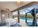 Inviting screened-in patio with a lounge bed, pool, hot tub and barbecue grill at 7845 Oak Reflection Loop, Davenport, FL 33837