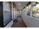 Enclosed front porch with wood flooring provides sheltered, flexible space with great natural light at 812 S Locust Ave, Sanford, FL 32771