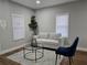 Bright living room featuring modern furniture, hardwood floors, and plenty of natural light from two windows at 812 S Locust Ave, Sanford, FL 32771
