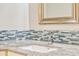 Bathroom vanity with a granite countertop, undermount sink, and decorative backsplash at 8922 Bay Cove Ct, Orlando, FL 32819