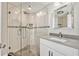 Modern bathroom with white tiled shower, glass doors, and a gray countertop vanity at 8922 Bay Cove Ct, Orlando, FL 32819