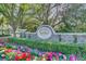 Stone monument sign at Bay Hill community entrance with colorful flower beds, manicured landscaping and mature shade trees at 8922 Bay Cove Ct, Orlando, FL 32819