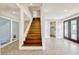 Entryway featuring wooden stairs, glass-paneled doors, and a view into a bathroom at 8922 Bay Cove Ct, Orlando, FL 32819