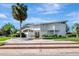 Stunning two-story white home featuring a lush landscaped yard and entryway with palm tree, offering great curb appeal at 8922 Bay Cove Ct, Orlando, FL 32819