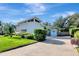 Well-maintained property with manicured lawn, lush landscaping, and a stylish modern home with ample parking at 8922 Bay Cove Ct, Orlando, FL 32819
