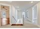 Bright hallway with stairway, modern glass railing, and doorways to other rooms at 8922 Bay Cove Ct, Orlando, FL 32819