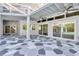 Large outdoor lanai with stylish geometric flooring, ceiling fans, and multiple access points to the home at 8922 Bay Cove Ct, Orlando, FL 32819