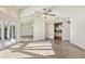 Bright and airy living room featuring a ceiling fan, gray tile floor, and view to the kitchen at 8922 Bay Cove Ct, Orlando, FL 32819