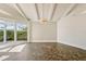 Bright living room with vaulted ceilings, white beams, a modern light fixture, and sliding glass doors to the patio at 8922 Bay Cove Ct, Orlando, FL 32819