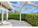 Outdoor patio featuring a pergola, lush hedges, and sliding glass doors, perfect for outdoor living at 8922 Bay Cove Ct, Orlando, FL 32819