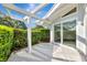 Covered patio features privacy landscaping and sliding glass door access to the home at 8922 Bay Cove Ct, Orlando, FL 32819