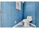 Bright blue powder room with custom wooden walls and a modern toilet at 8922 Bay Cove Ct, Orlando, FL 32819