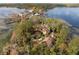 Magnificent lakefront home with a circular driveway, lush trees, and a clay tile roof at 9291 Point Cypress Dr, Orlando, FL 32836