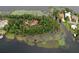 Breathtaking aerial view of the home nestled among mature trees on a private island at 9291 Point Cypress Dr, Orlando, FL 32836