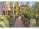 Tranquil bridge walkway through lush greenery, leading to an elegant Mediterranean-style home at 9291 Point Cypress Dr, Orlando, FL 32836