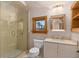 Bright bathroom features glass enclosed shower, cream vanity with brass faucets, and a window at 9291 Point Cypress Dr, Orlando, FL 32836