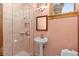 Classic bathroom features a pedestal sink, a glass enclosed shower and muted peach walls at 9291 Point Cypress Dr, Orlando, FL 32836