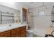 Bathroom with a tub and shower, a wooden vanity, and a large decorative mirror at 9291 Point Cypress Dr, Orlando, FL 32836
