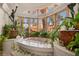 Spa-like bathroom with a soaking tub, bay windows, and decorative plants at 9291 Point Cypress Dr, Orlando, FL 32836