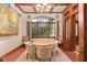 Elegant breakfast nook features a round table, patterned chairs, wood floors and beams and natural light at 9291 Point Cypress Dr, Orlando, FL 32836