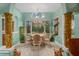 Bright dining room featuring a chandelier, decorative columns, and garden views through large windows at 9291 Point Cypress Dr, Orlando, FL 32836
