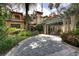 Spacious stone driveway leading to a home with a portico and lush landscaping at 9291 Point Cypress Dr, Orlando, FL 32836