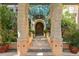 A grand entrance features stone pillars, lush greenery, and a decorative glass awning at 9291 Point Cypress Dr, Orlando, FL 32836