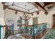 Stunning foyer with ornate wrought iron staircase, chandelier, and decorative tapestry at 9291 Point Cypress Dr, Orlando, FL 32836