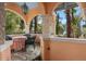Covered patio with stone columns, arched openings, and a serene view of the lake at 9291 Point Cypress Dr, Orlando, FL 32836