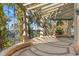 Wide patio area with a pergola and a view of the lake surrounded by trees at 9291 Point Cypress Dr, Orlando, FL 32836