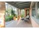 Covered patio area with stone pillars, tile flooring, comfortable seating, and lush landscaping at 9291 Point Cypress Dr, Orlando, FL 32836
