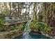 Outdoor lounge chairs on deck near tranquil pool with tropical plants at 9291 Point Cypress Dr, Orlando, FL 32836