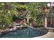 Outdoor swimming pool area featuring lush tropical landscaping and plants at 9291 Point Cypress Dr, Orlando, FL 32836