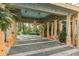 Covered portico area featuring stone columns, patterned flooring, and lush greenery at 9291 Point Cypress Dr, Orlando, FL 32836
