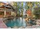Beautiful swimming pool with rock features and lush landscaping, creating a relaxing backyard retreat at 9291 Point Cypress Dr, Orlando, FL 32836