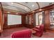 Cozy home theater with tiered seating, built-in shelving, and a large projection screen at 9291 Point Cypress Dr, Orlando, FL 32836