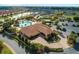 Aerial view of the community clubhouse, pool, and lush landscaping at 10144 Lake Miona Way, Oxford, FL 34484