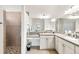 Bright bathroom with double sink vanity and walk-in shower with neutral tile at 10144 Lake Miona Way, Oxford, FL 34484