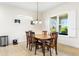 Bright dining area featuring tile floors, a modern chandelier, a window with shutter, and views of the outdoor scenery at 10144 Lake Miona Way, Oxford, FL 34484