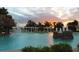 Beautiful swimming pool at sunset with rock waterfall and fountains feature at 10144 Lake Miona Way, Oxford, FL 34484