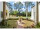 Landscaped backyard featuring a pool with a rock waterfall, lush greenery, and a brick pathway at 11324 Bridge House Rd, Windermere, FL 34786