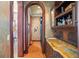 Hallway wet bar featuring custom cabinetry, copper sink, granite counters and brick floors at 11324 Bridge House Rd, Windermere, FL 34786