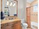 Bright bathroom with a beautiful vanity with a marble countertop, decorative tiles, and patterned shower curtain at 11324 Bridge House Rd, Windermere, FL 34786