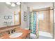 Bathroom featuring marble countertop, decorated mirror, and shower-tub combo with multicolored shower curtain at 11324 Bridge House Rd, Windermere, FL 34786