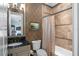 Cozy bathroom featuring a shower-tub combo, granite countertop, and decorative mirror at 11324 Bridge House Rd, Windermere, FL 34786