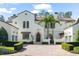 Front exterior of a two-story home with a brick driveway and three-car garage at 11324 Bridge House Rd, Windermere, FL 34786