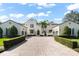 Elegant home featuring a brick driveway, manicured hedges, and classic architectural details at 11324 Bridge House Rd, Windermere, FL 34786