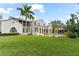 Exterior elevation featuring lush landscaped backyard, pool, and an arched loggia at 11324 Bridge House Rd, Windermere, FL 34786