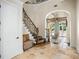 Grand foyer with curved staircase, stone floors, and arched doorways offers a luxurious welcome at 11324 Bridge House Rd, Windermere, FL 34786